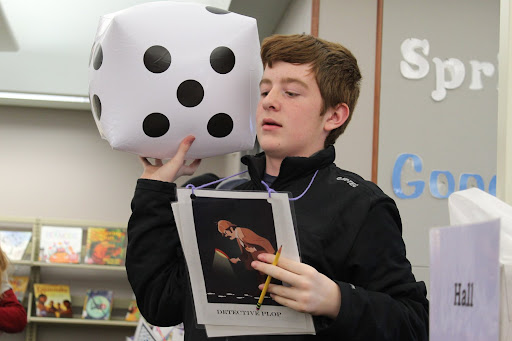 young man with a big dice and a pencil in his hand