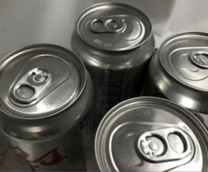 Black and white image of 4 soda cans.